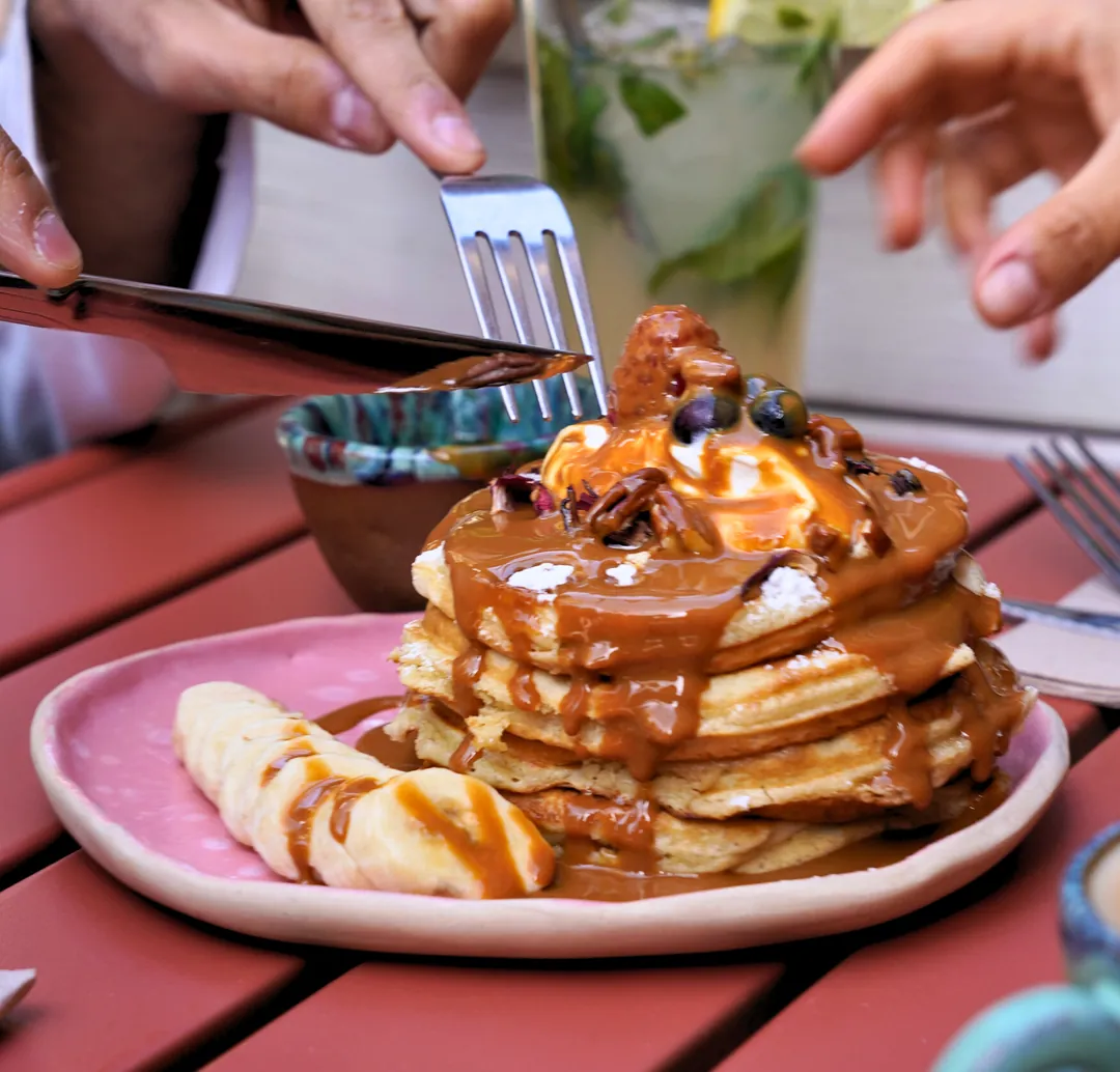 Pancakes with berries as the syrup is poured