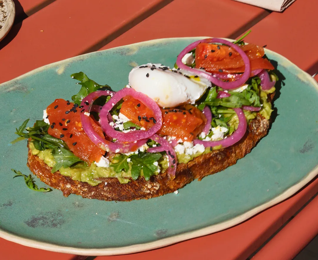 Smashed avocado toast with a poached egg, top view